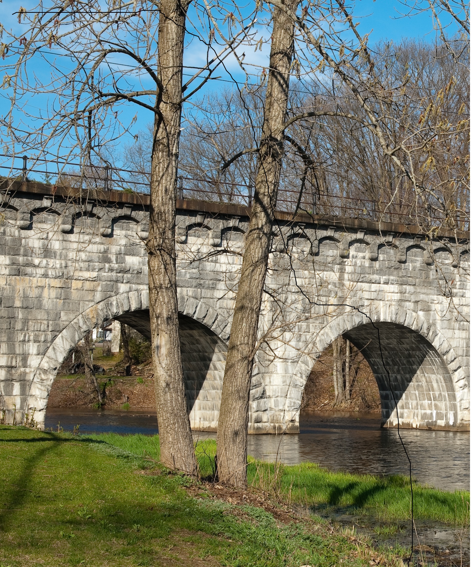 Stone arch bridge for train transportation. Image was taken during a beautiful day in New England. Useful image for any New England, train, bridge, aqueduct theme.